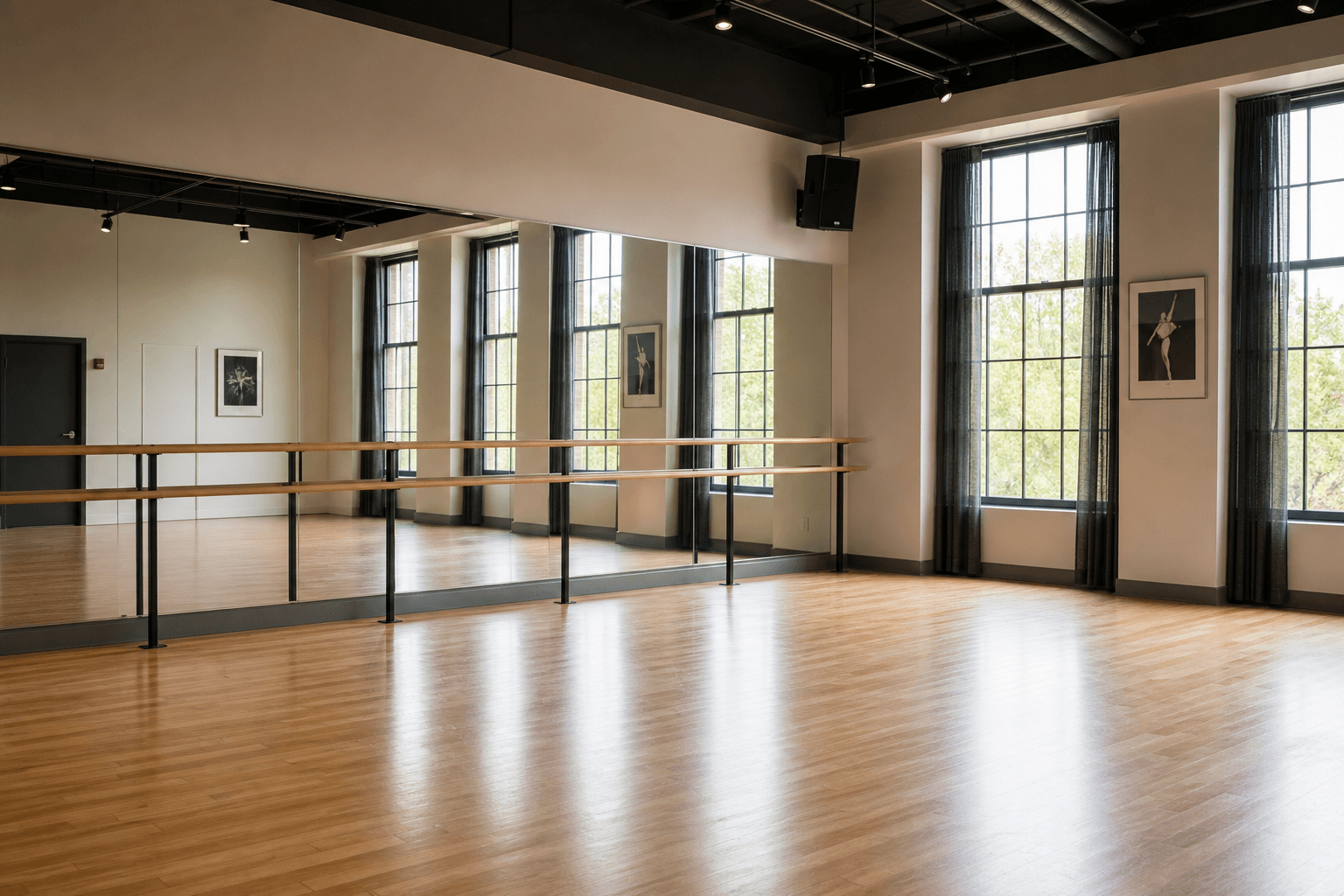 A dance studio with mirrored wall, polished floor, and ballet barres